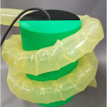 A vine robot wrapped around a cylinder.